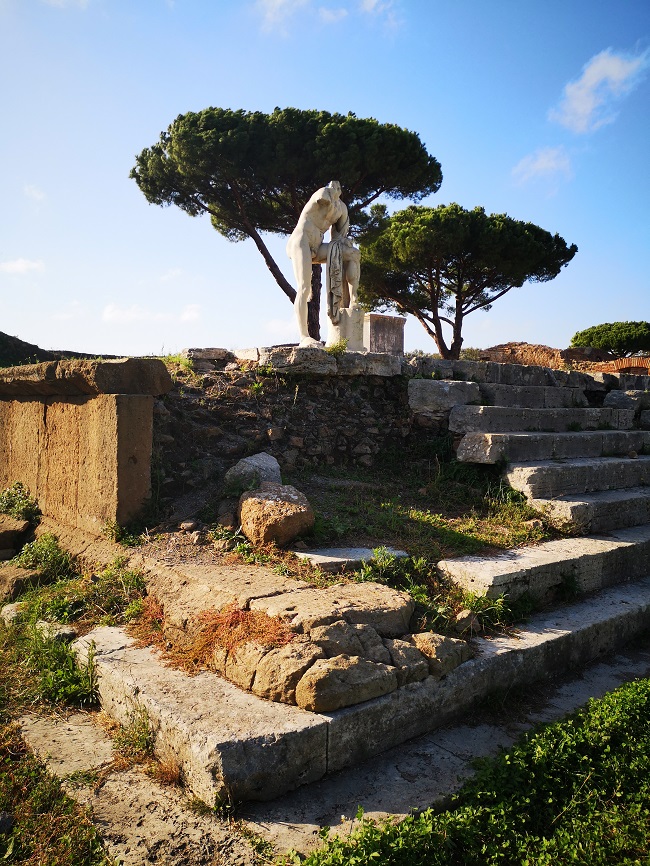 Ostia antica statue with pine tree in the background and remains of building