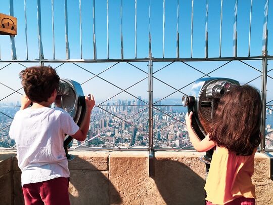 Kids looking out towards Manhattan from the top of the Empire State Building new York City