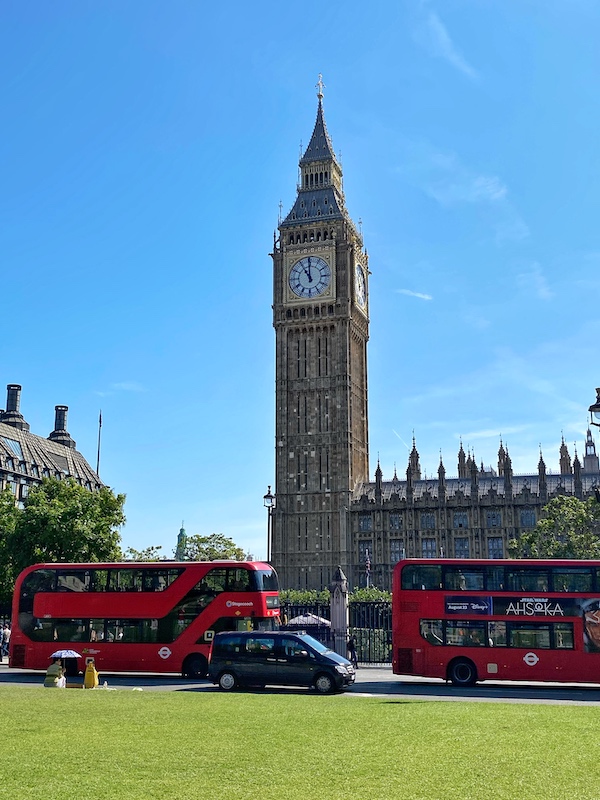 Big Ben in London with two double decker buses in front