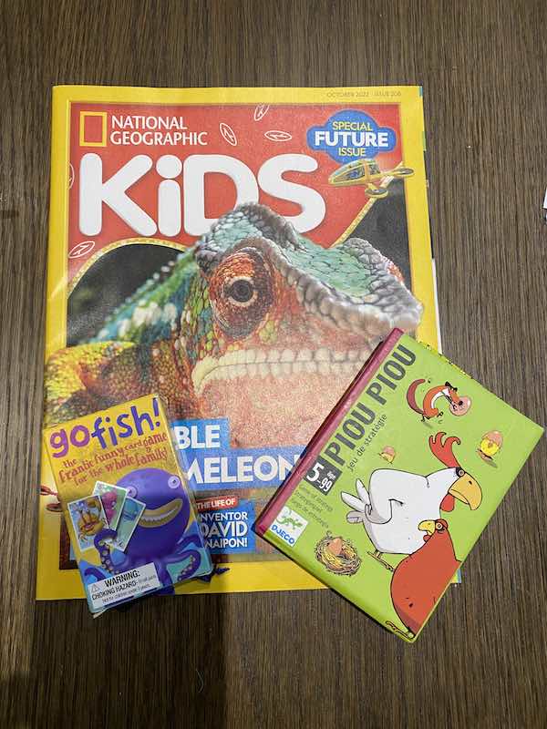 Photo of kids Nat geo magazine, go fish card and piou piou game