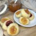 my thumbprint cookies, ready and on a white table and wooden board with jam jar in the background