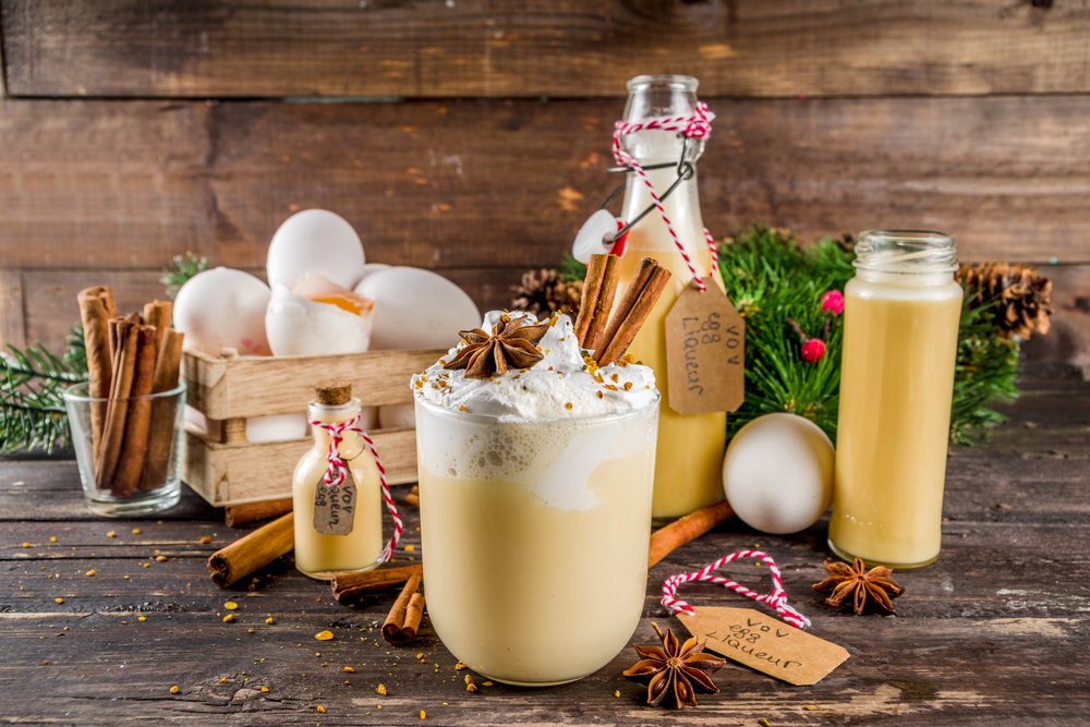 Italian bombarding drink, light yellow with whipped cream, staged on wooden surface with seasonal decorations