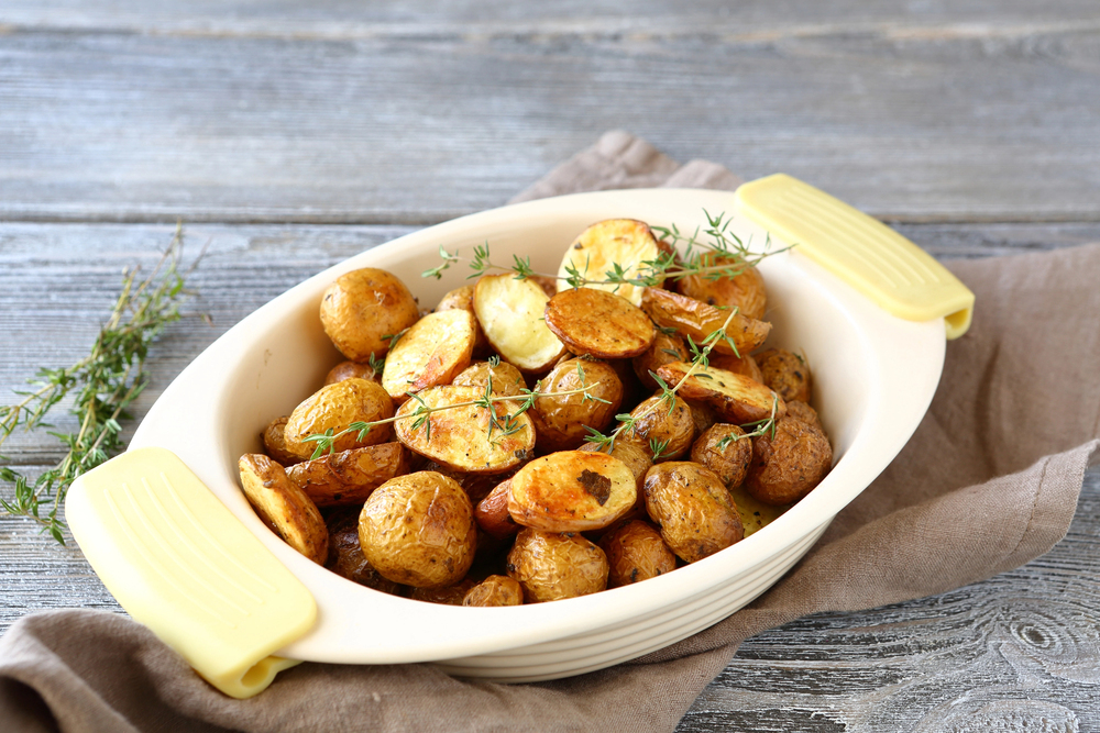 herby roasted baby potatoes in white oven dish